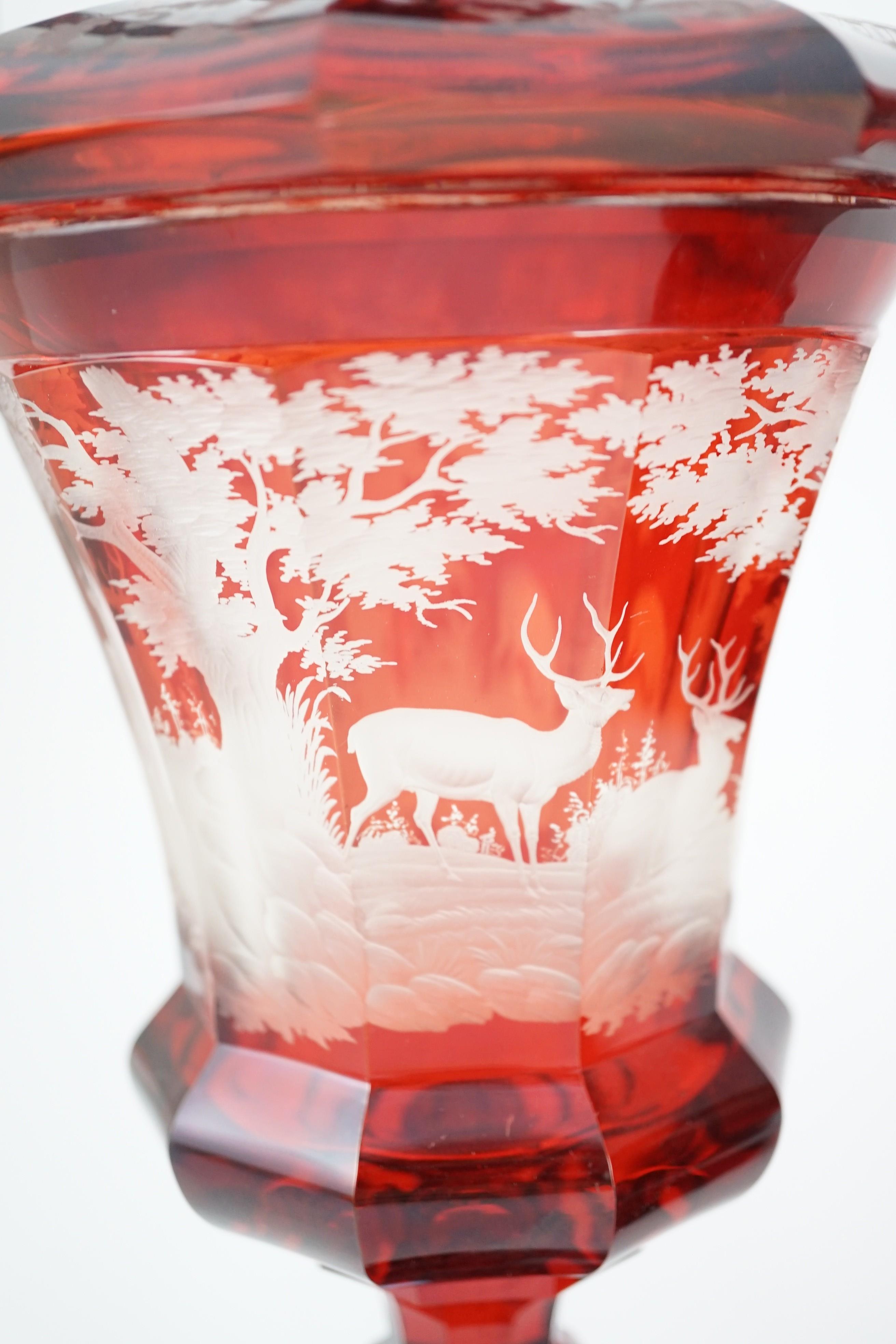 Three large Bohemian ruby stained glass goblets and covers, late 19th century, 38.5cm to 50.5cm high, rim chips